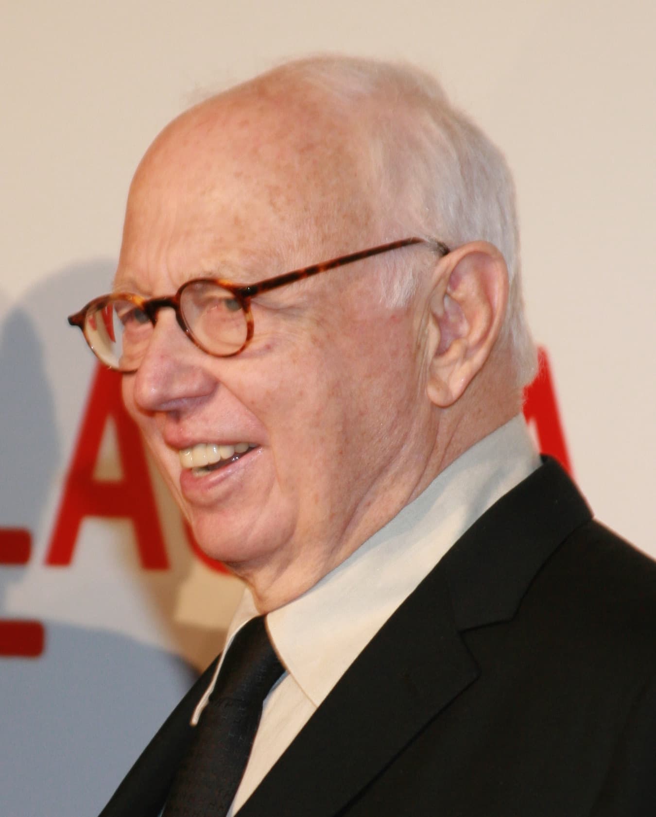 Ellsworth Kelly in tortoiseshell glasses, laughing.