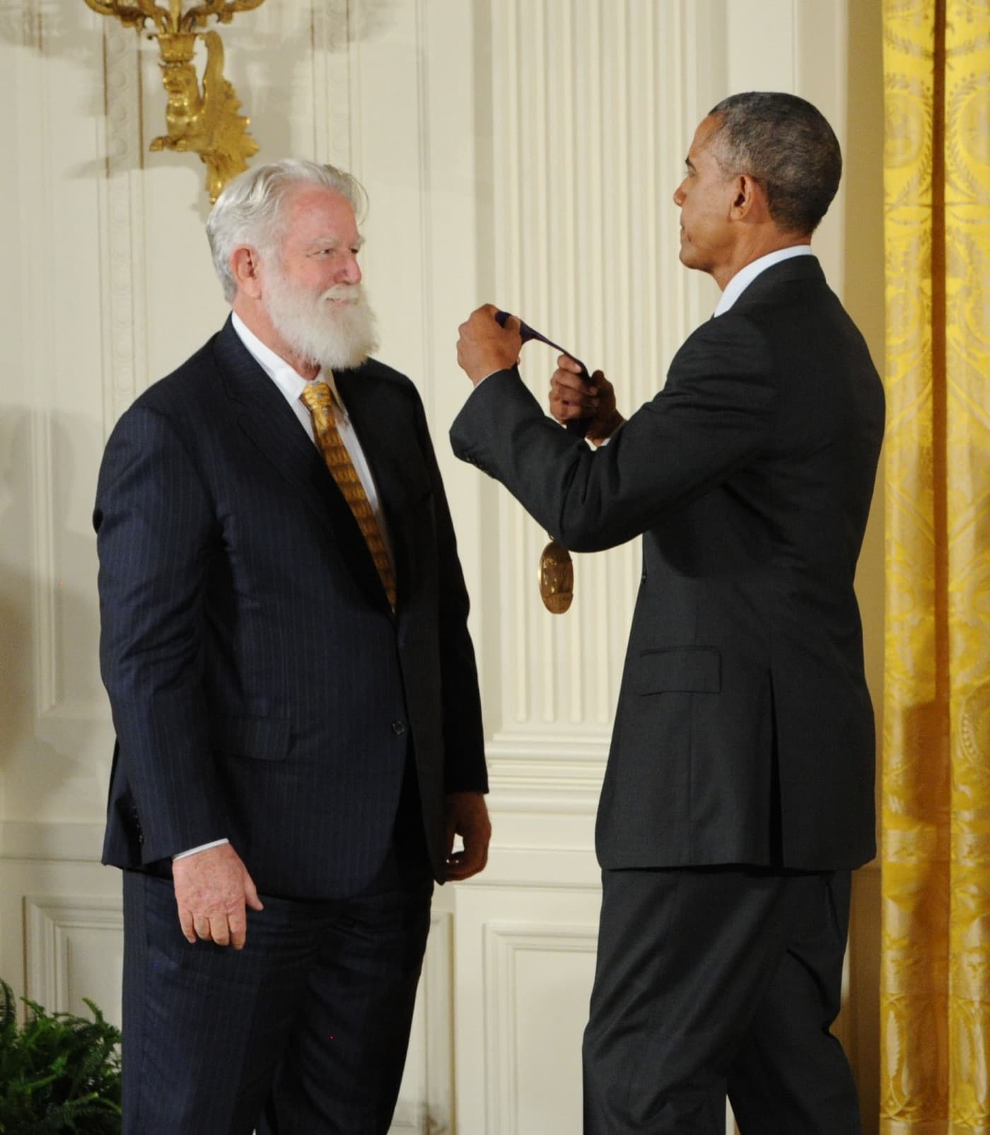 President Obama placing the National Medal of Arts around James Turrell's neck.