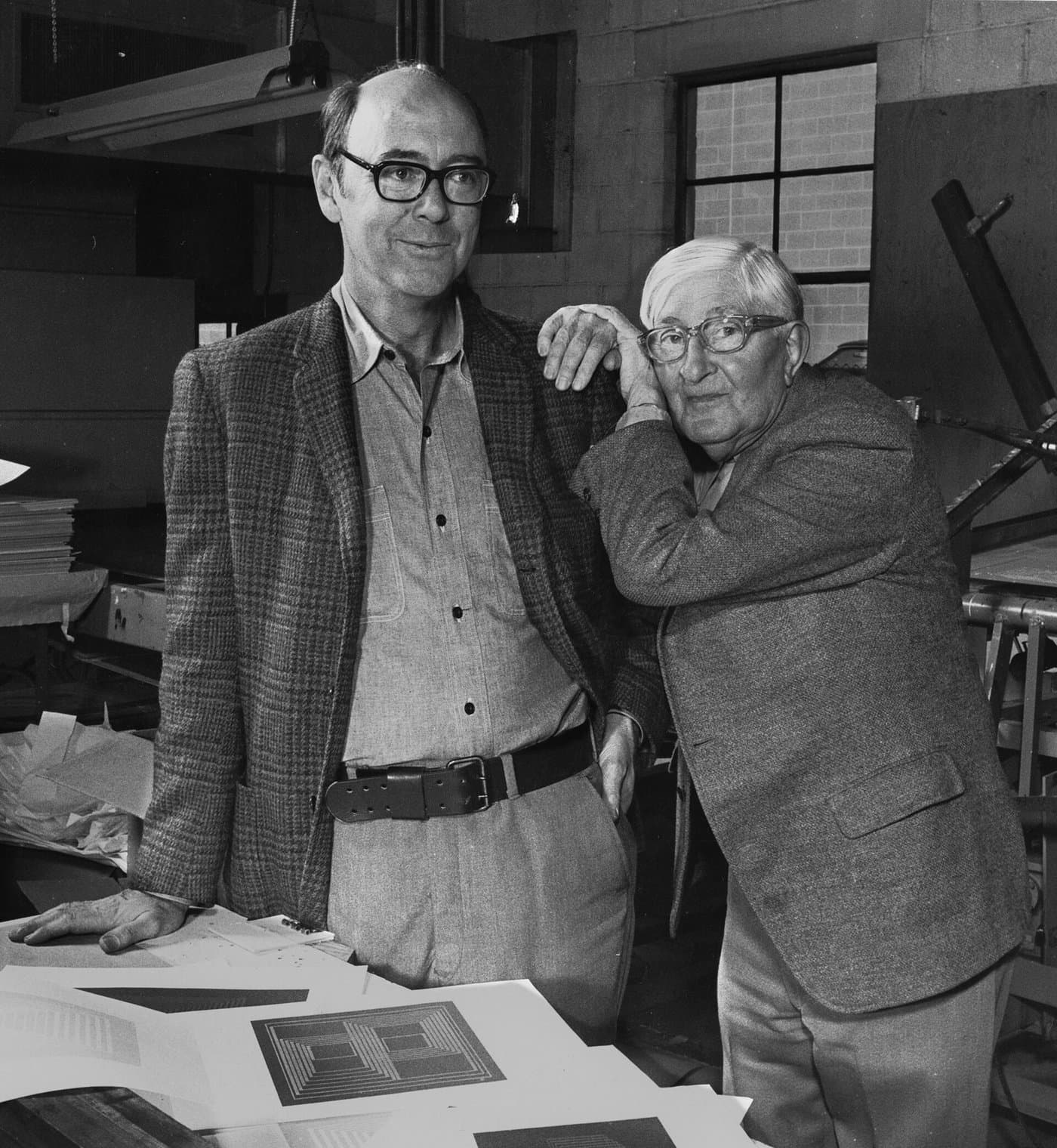 Josef Albers, in glasses, leaning beside Norman Ives in a print workshop.