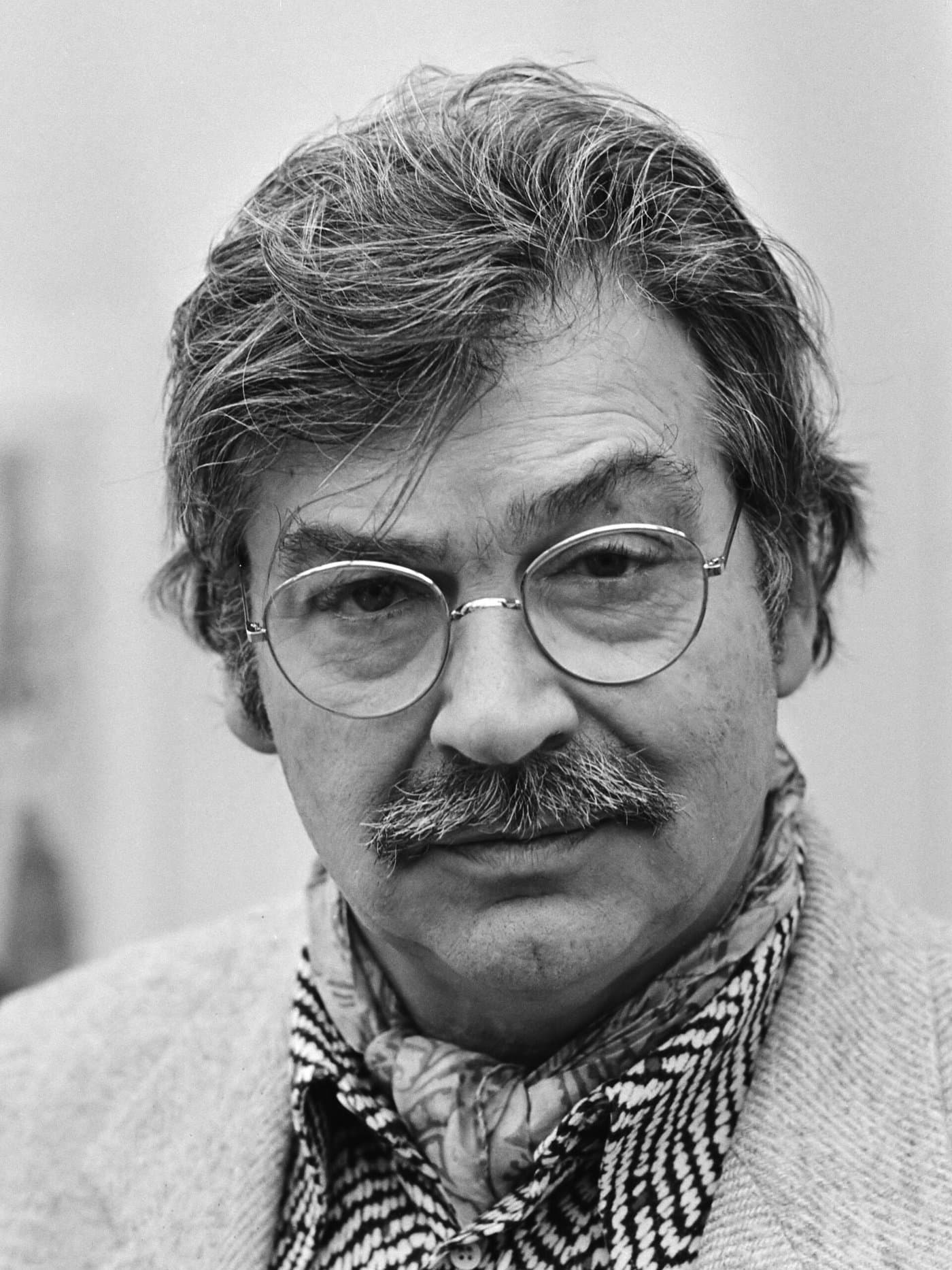Karel Appel with tousled grey hair and wire-rimmed glasses.