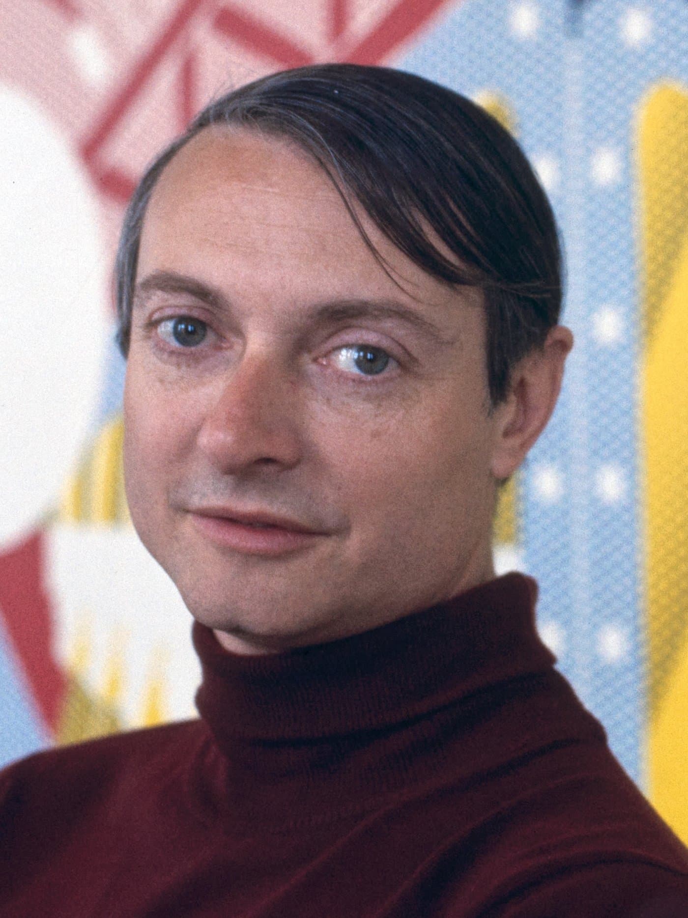 Roy Lichtenstein, close up, in front of one of his dot paintings.
