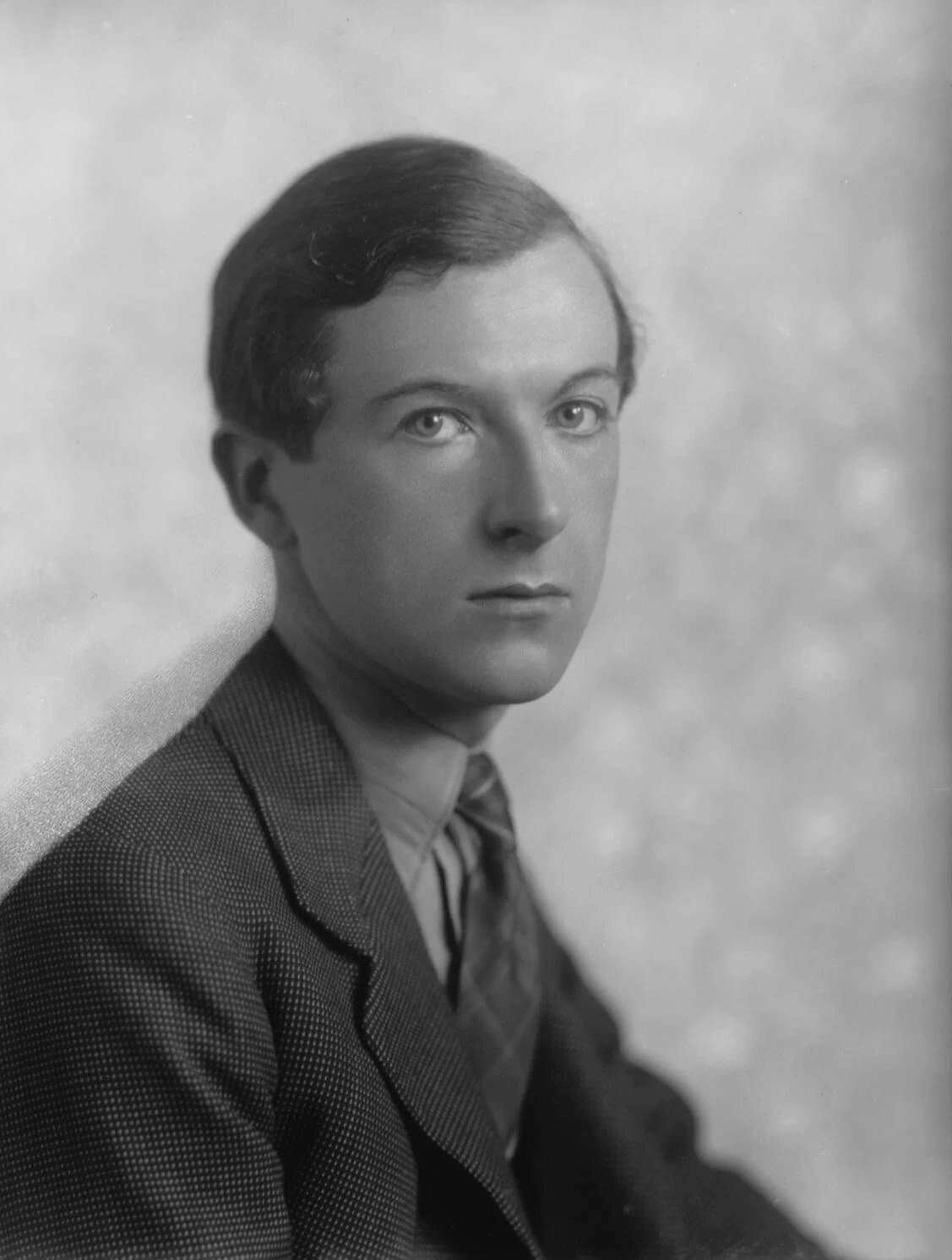 Black and white studio portrait of the young Cecil Beaton in a jacket and tie