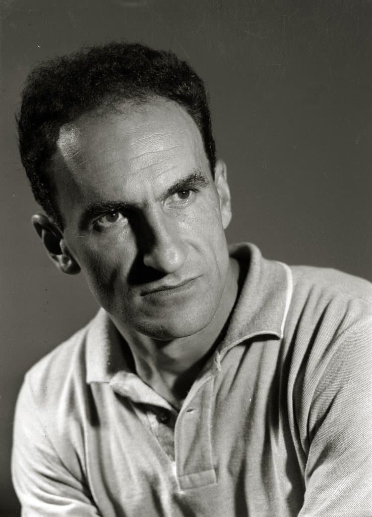 Eduardo Chillida with dark hair, resting his chin on his hand.