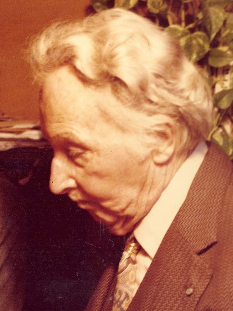 Erté in old age, in profile, looking down.