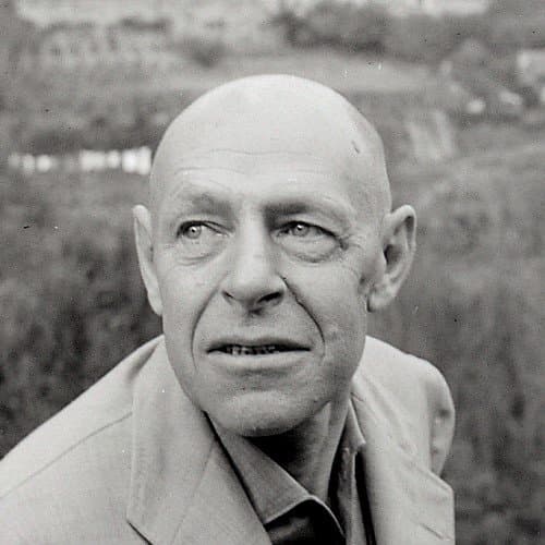 Jean Dubuffet, bald, in close-up, looking to one side.