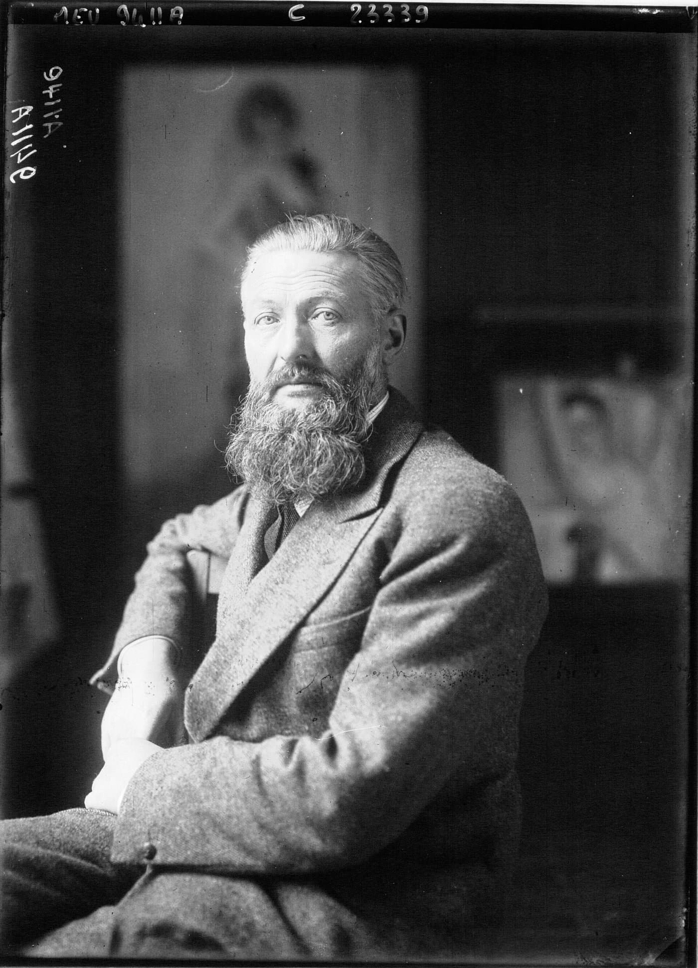 Kees van Dongen with a full beard, seated in his studio.