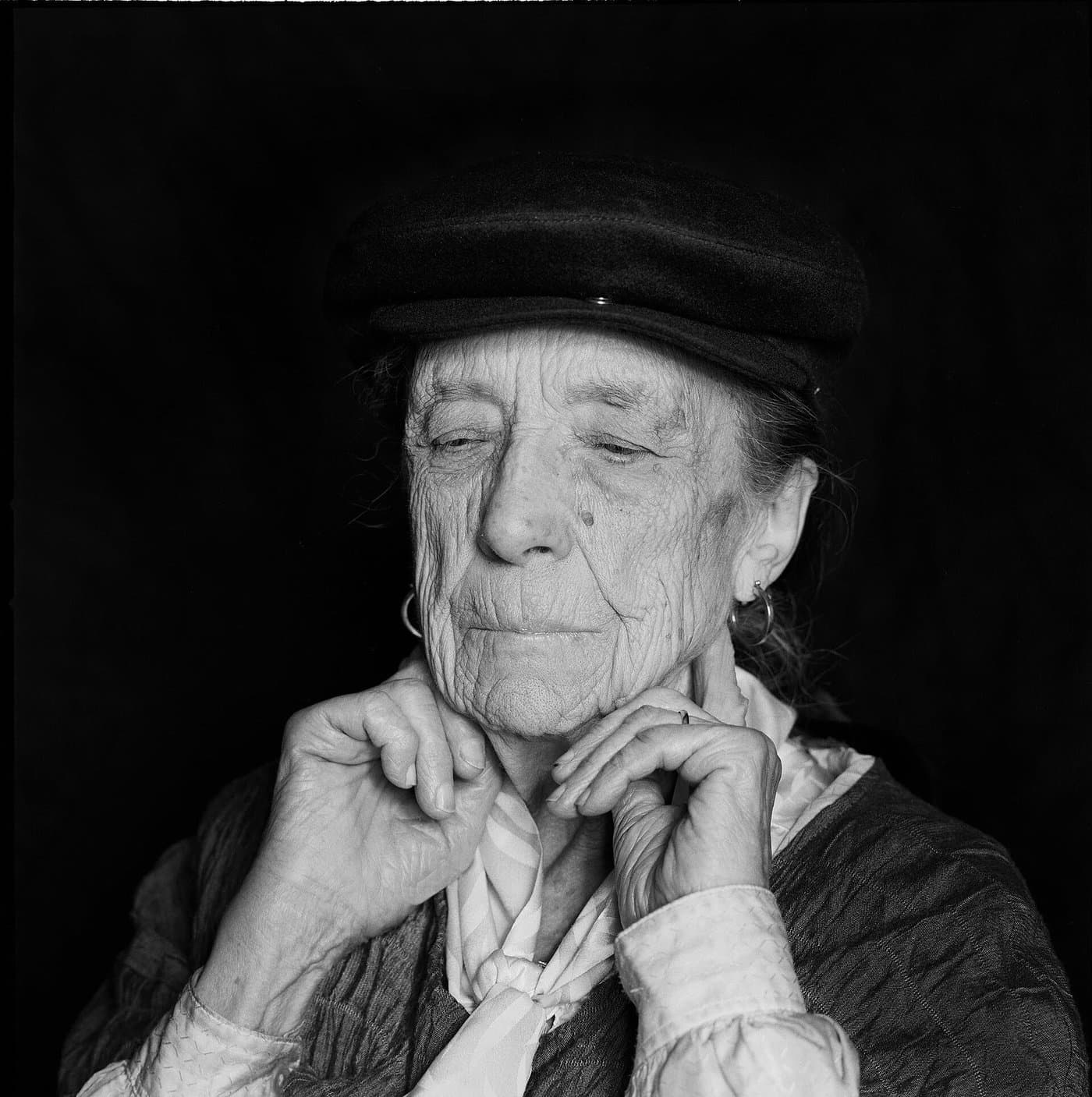 Louise Bourgeois in a dark cap, her chin resting on her hands.