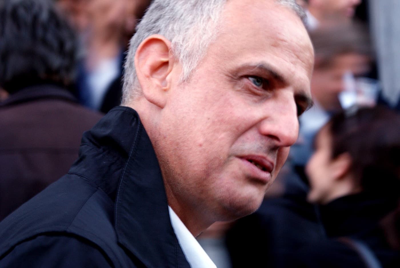 Luc Tuymans, grey-haired, in a dark jacket, looking to one side.