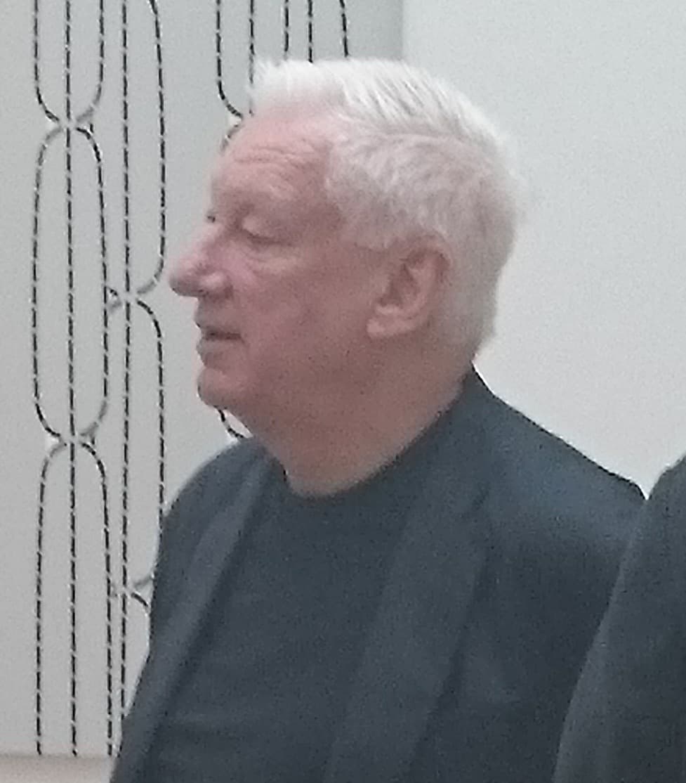 Michael Craig-Martin, white-haired, in profile.
