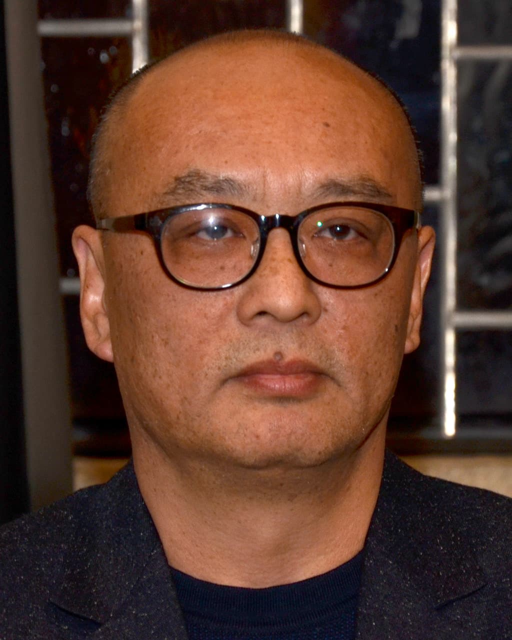 Zhang Xiaogang, close up, in dark-rimmed glasses.