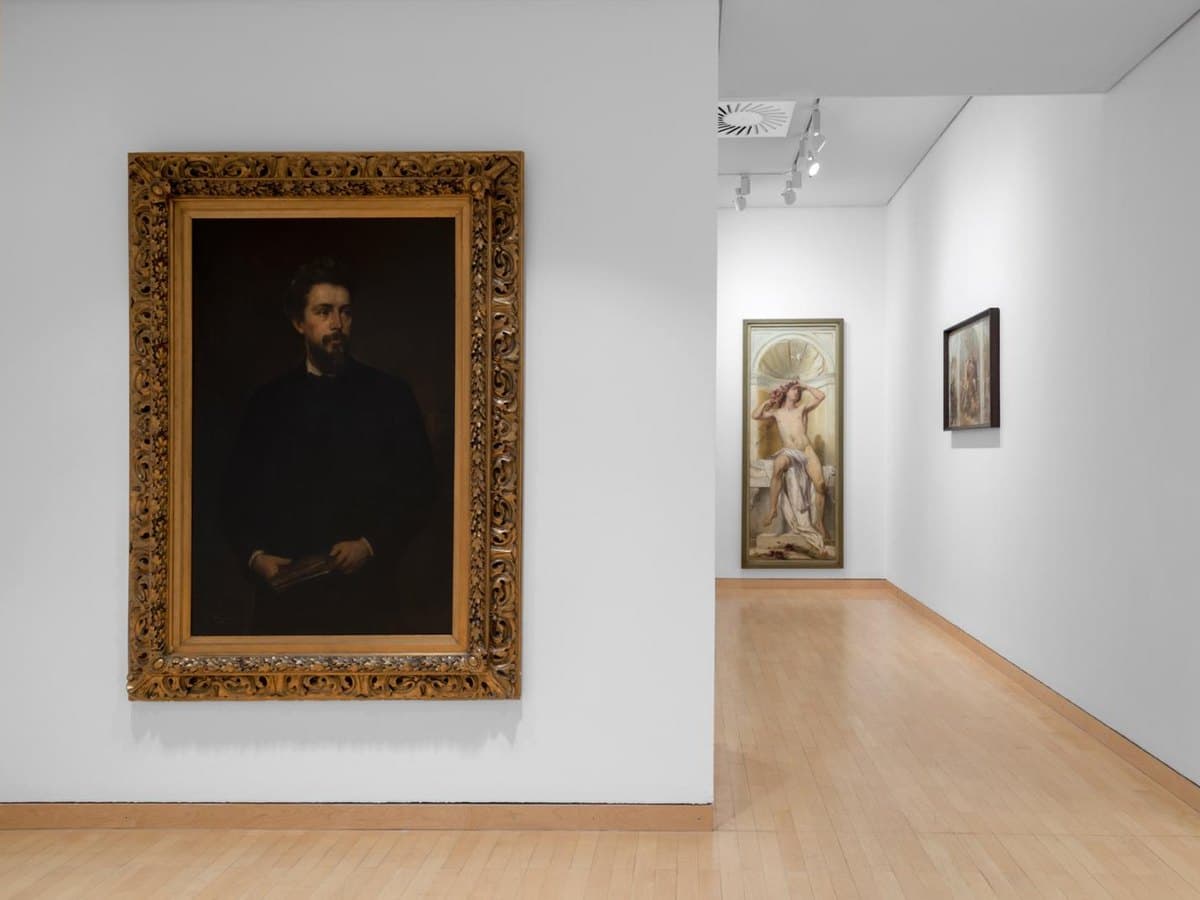 Gallery hang: a large gilt-framed portrait, with further works along the room beyond