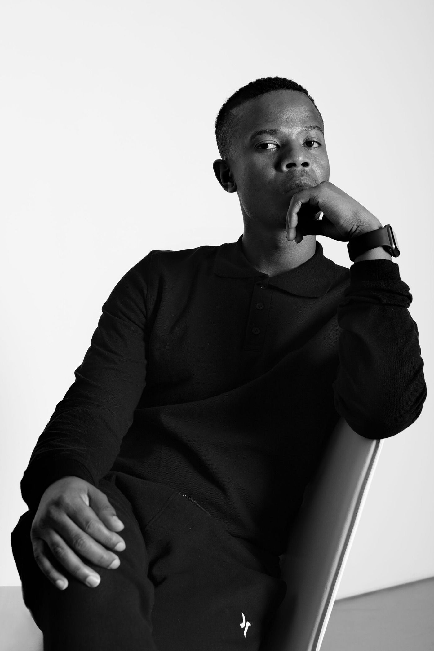Black and white portrait of Cinga Samson seated, his chin resting on his hand