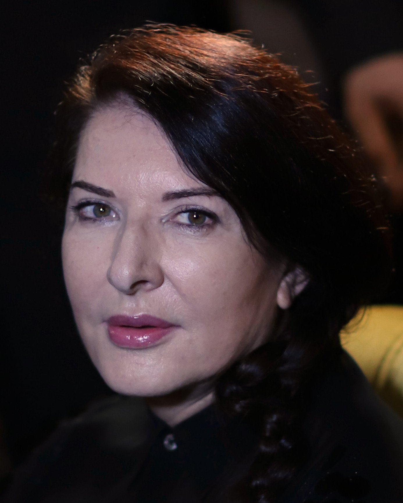Marina Abramović, close up, with long dark hair.
